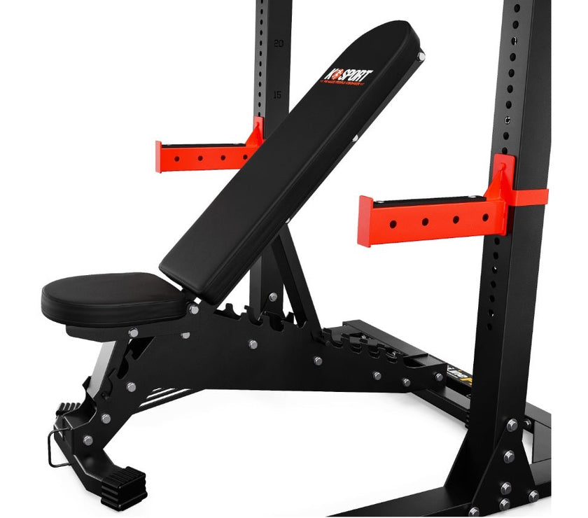 Black weight bench with red padding on a white background