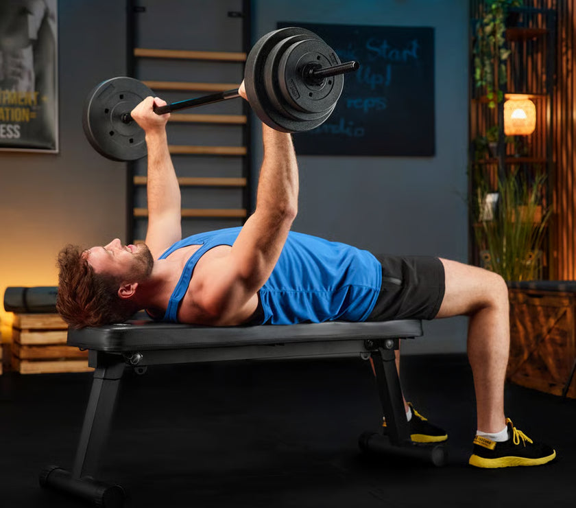 Man performing bench press with barbell in a home gym setting