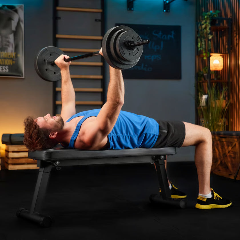Man performing bench press with barbell in a home gym setting