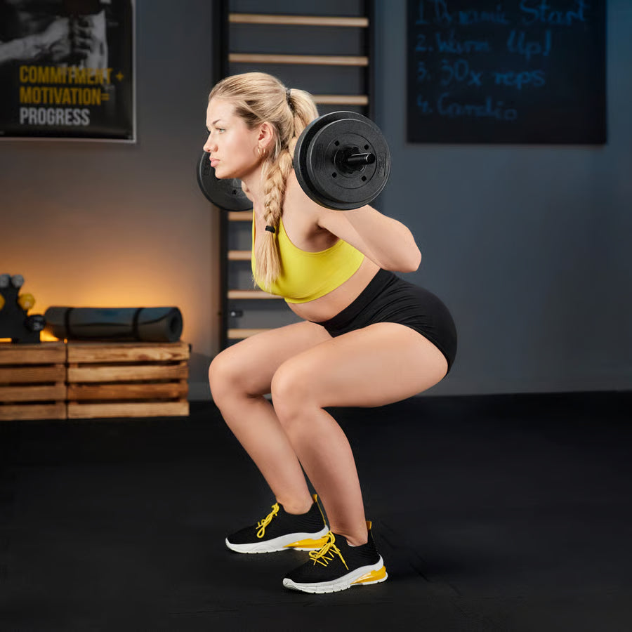 Woman performing squats with a barbell in a gym setting