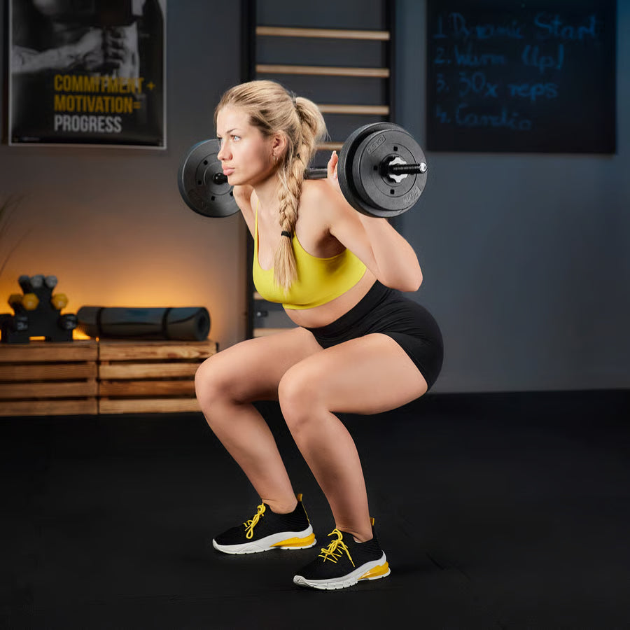 Woman performing squats with a barbell in a gym setting