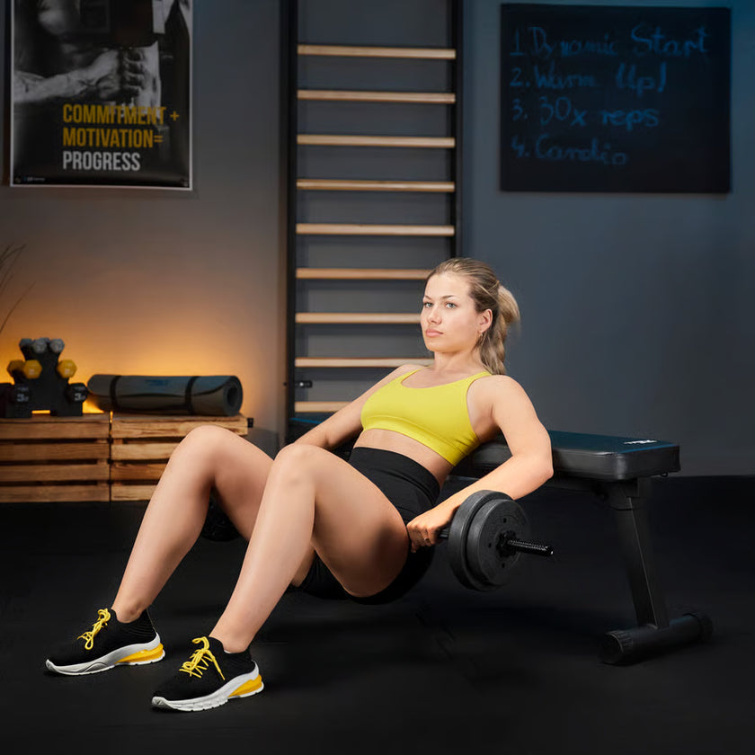 Woman exercising on a bench press in a gym setting with motivational posters on the wall.